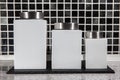 Square white storage jars in modern black and white tiled kitchen.