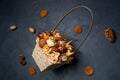 Square wicker basket filled with dried fruits and nuts on a dark blue background