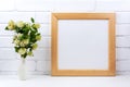 Square wooden picture frame mockup with white spirea