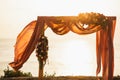 Square wooden wedding arch on outdoor sunset red color wedding ceremony