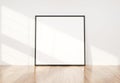 Black frame leaning in bright white interior with wooden floor mockup 3D rendering