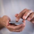 Squared image of young caucasian man using apps on a touchscreen smartphone Royalty Free Stock Photo