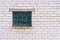 Squares of corrugated green glass in the brick wall