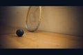 Squash ball on court with squash racket ready to play Royalty Free Stock Photo