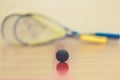 Squash ball on court with two squash rockets ready to play