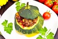 Squash green stuffed with meat on dark board