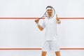 A squash player on a squash court with the racket. White sportswear. Royalty Free Stock Photo