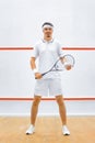 A squash player on a squash court with the racket. White sportswear. Royalty Free Stock Photo