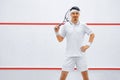 A squash player on a squash court with the racket. White sportswear. Royalty Free Stock Photo