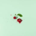 Squashed red cherry berry fruit on pastel green background. Summe red ripe juicy fruit concept Royalty Free Stock Photo