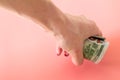 squeezed money on woman fist. woman hand taking a roll of dollars Royalty Free Stock Photo