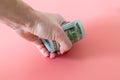 Squeezed money on woman fist. woman hand taking a roll of dollars Royalty Free Stock Photo