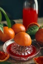 Squeezer with half of sicilian orange on wooden table Royalty Free Stock Photo