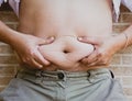Squeezing belly fat around belly button Royalty Free Stock Photo