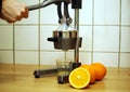 Squeezing an orange with a manual press. Royalty Free Stock Photo