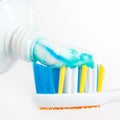 Squeezing toothpaste from a tube on the toothbrush closeup Royalty Free Stock Photo