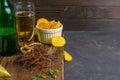 Squid dark cobweb with beer, lemon and potato chips on dark wooden board. Snack on fish with beer. Front views with clear space Royalty Free Stock Photo