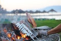 squid in man's hand, fish spit on fire, beach background,