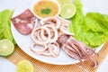 Squid rings on white plate, Fresh squid cooked boiled with lettuce vegetable salad lemon lime and seafood sauce on table Royalty Free Stock Photo