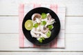 Squid salad bowl with lemon herbs and spices on wooden background top view - Tentacles octopus cooked appetizer food seafood Royalty Free Stock Photo