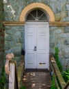 Beautiful stone and gilded facade of aged building with weathered ramp and white door