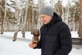 A squirrel sits on a man's arm, eating nuts. The trees are covered in snow, a winter park Royalty Free Stock Photo