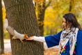 A squirrel sitting on a tree trunk takes nuts from a person`s hand in an autumn park Royalty Free Stock Photo