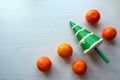 Squish toy in the form of a Christmas tree with orange tangerines on a light background, top view, close-up, space for text-the