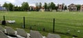 Sremska Mitrovica, Serbia May 22, 2020. School football field. Green grass behind a wire mesh fence. Free spectator seats. No