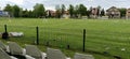 Sremska Mitrovica, Serbia May 22, 2020. School football field. Green grass behind a wire mesh fence. Free spectator seats.