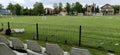 Sremska Mitrovica, Serbia May 22, 2020. School football field. Green grass behind a wire mesh fence. Free spectator seats. No