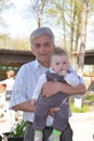 Sremska Mitrovica, Serbia / October 10, 2019: child in the arms of an older man. The child looks forward and holds his hand near