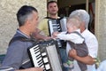 Sremska Mitrovica, Serbia / October 10, 2019: a child in the arms of a woman. The child touches the accordion. Musicians play