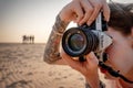 Sri Lanka, February 2020. Editorial image. A woman takes a photo on a Nikon film camera on the shore of the ocean. Close