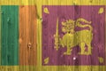 Sri Lanka flag depicted in bright paint colors on old wooden wall. Textured banner on rough background