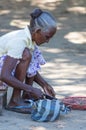 An unknown local woman is sorting out the greens bought at the market for further cooking