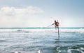 Sri lanka traditional `stick`- method fish catching Fisherman in the Indian Ocean waves. Royalty Free Stock Photo