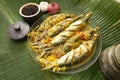 Sri Lankan style Salman fish curry on a Glass plate with spices on a banana leaf