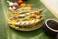 Sri Lankan style Salman fish curry on a Glass plate with spices on a banana leaf