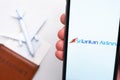 Srilankan Airlines app on a smartphone screen in mans hand. A toy plane, passport and tickets are on the table. November Royalty Free Stock Photo