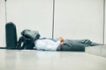Ssh, they wont know Im taking a nap. an unrecognizable businessman sleeping in an airport terminal and covering his face Royalty Free Stock Photo