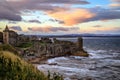 St. Andrews Castle ruins with the high tide and deep orange sunset casting beautiful shadows in Fife, Scotland Royalty Free Stock Photo