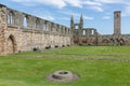 Ruin of Scottish medieval cathedral with tower and resting people