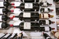 Variety of wine in glass bottles mounted on metal stand in modern supermarket