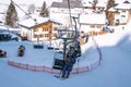 Skiers riding chairlifts at ski resort during beautiful sunny day