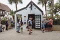 Tourists linger around the Old Town Trolley information visitors booth, looking and