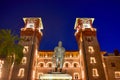 Illuminated Lightner Museum and Henry Flager statue on blue night background in Florida`s Historic Coast.