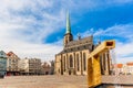 St. Bartholomew`s Cathedral in the main square of Plzen with a fountain on the foreground against blue sky and clouds sunny day. Royalty Free Stock Photo