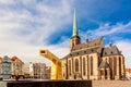 St. Bartholomew`s Cathedral in the main square of Plzen with a fountain on the foreground against blue sky and clouds sunny day.