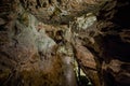 St. Beatus Cave and waterfalls above Thunersee, Sundlauenen, Switzerland. Falls are running down the mountain with a green grass